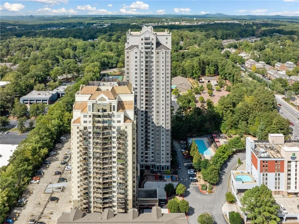Drone / aerial view of a pool and a heavily wooded area