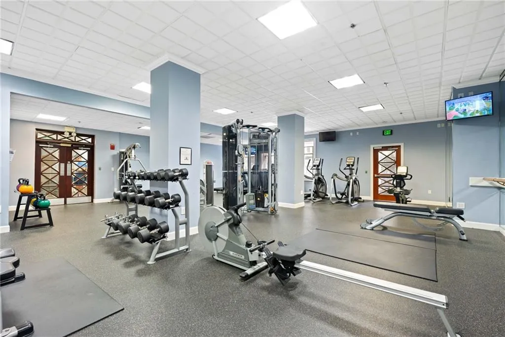 Exercise room with baseboards and a paneled ceiling