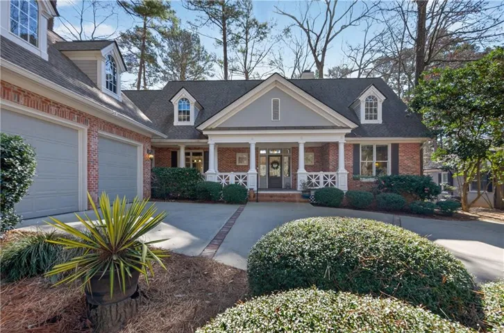 View of front of home featuring a porch, driveway, and brick siding