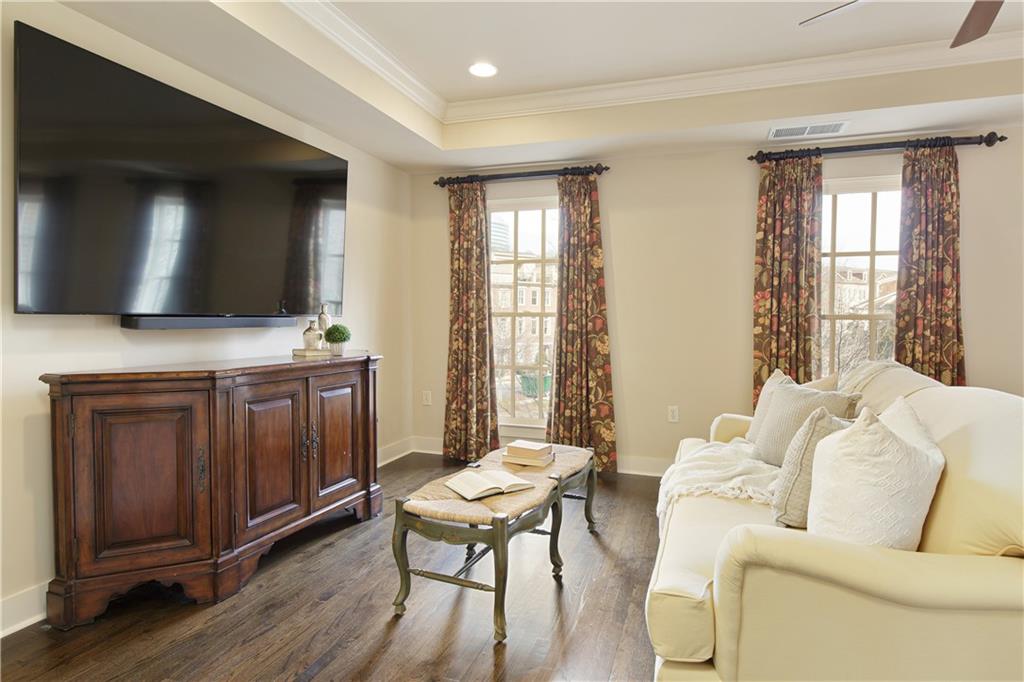 Featuring the expansive primary bedroom suite, adorned with hardwood floors and a sense of luxury and comfort.