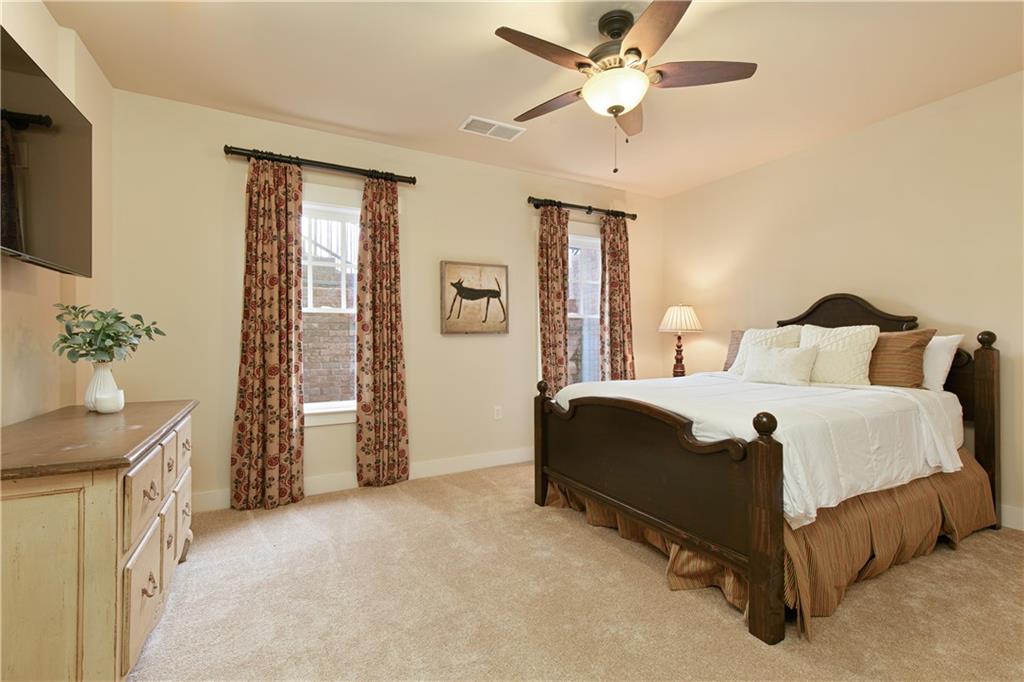 The unique design of the terrace level ensuite bedroom, which features plush carpeting installed over engineered hardwood flooring, blending coziness and elegance, and providing a versatile and comfortable living space.