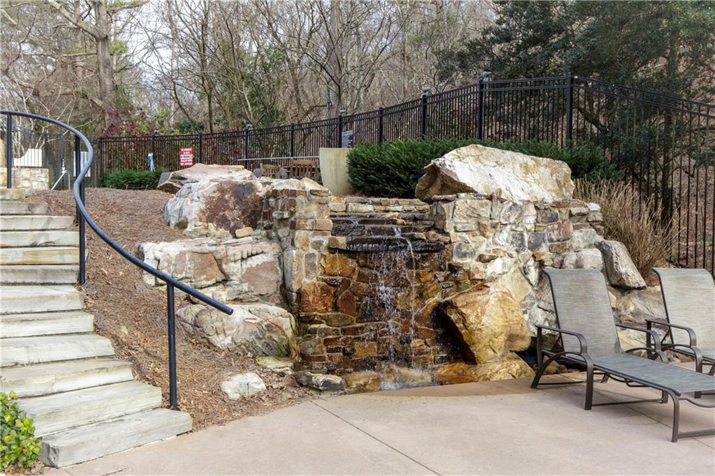 The community's elegant pool, complemented by a soothing waterfall feature, creating a tranquil and visually stunning environment for relaxation, swimming, and enjoying the serene sound of cascading water.