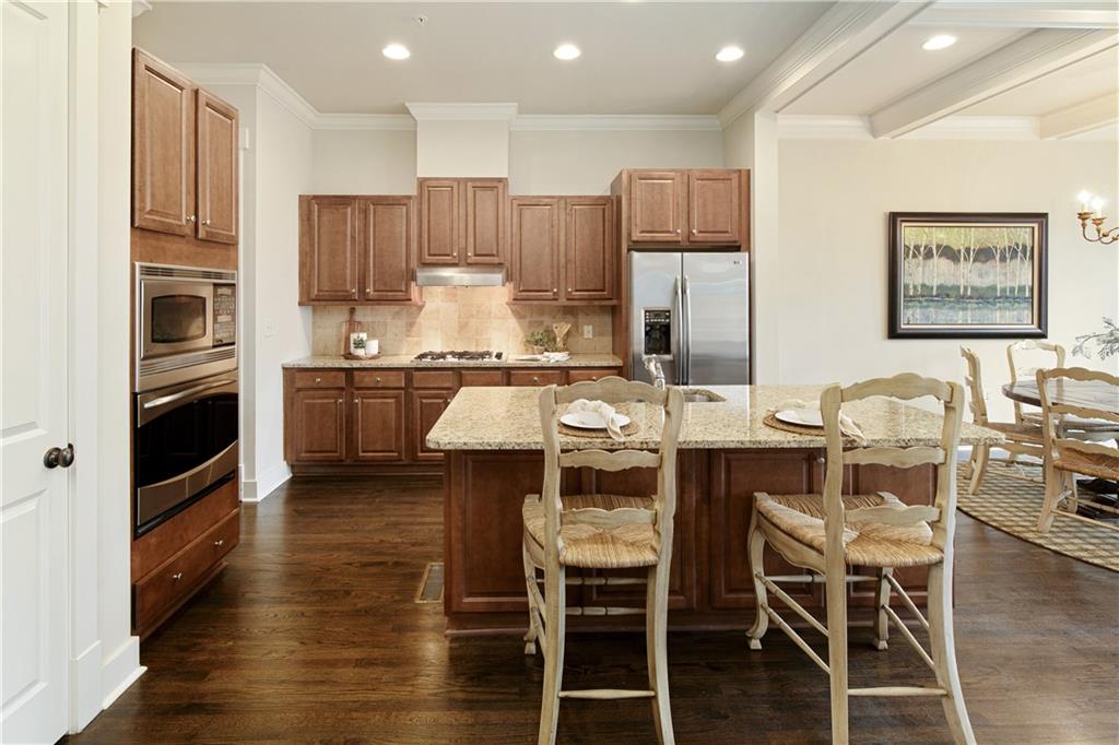 Featuring the expansive hardwood floors that run throughout the townhome, their gleaming surface reflecting light and adding a touch of elegance and warmth to every room, seamlessly connecting the living spaces.