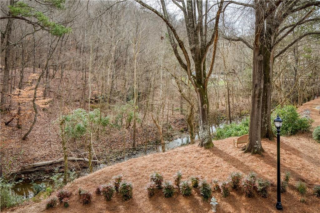 Capturing the serene moment of sitting on a bench within the property, offering a peaceful escape to enjoy the soothing sounds of nature right in the heart of the city, blending urban convenience with a tranquil, natural oasis.