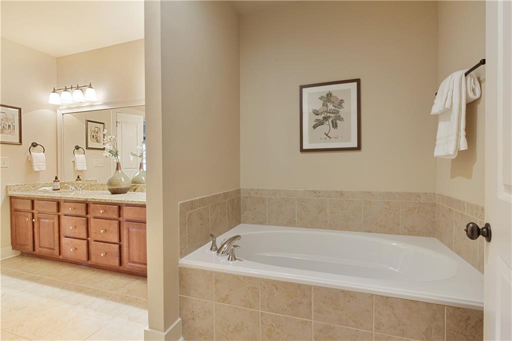 The well-appointed bathroom features a separate, spacious shower and a deep soaking tub, offering a perfect blend of modern convenience and indulgent relaxation, ideal for unwinding after a long day.