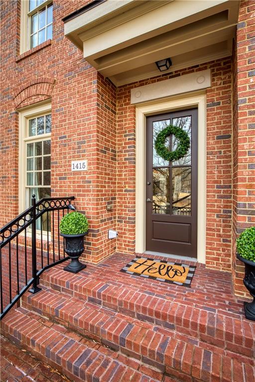 Displaying the townhome's inviting entrance, framed by a beautifully crafted brick-covered entryway that provides a warm and elegant welcome, blending seamlessly with the sophisticated architecture of the One River Place community.