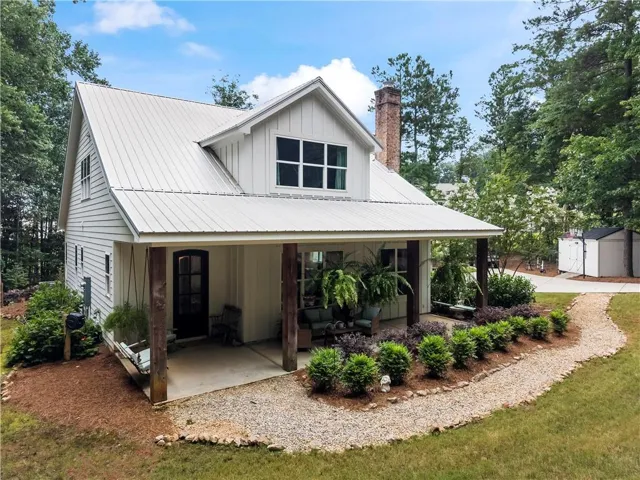 White board-and-batten and horizontal siding exterior with a metal roof