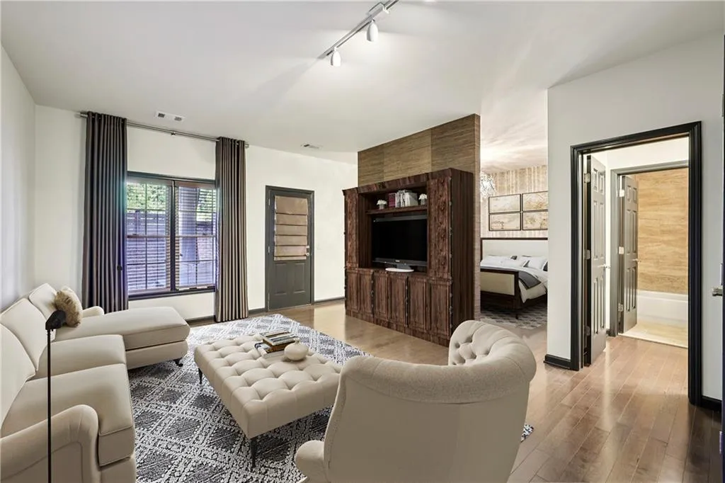 Terrace level that includes a full bath, sitting area and bedroom behind the partial. The partial wall is not load bearing should you want to repurpose this level. Door with blinds leads to the finished outdoor space.