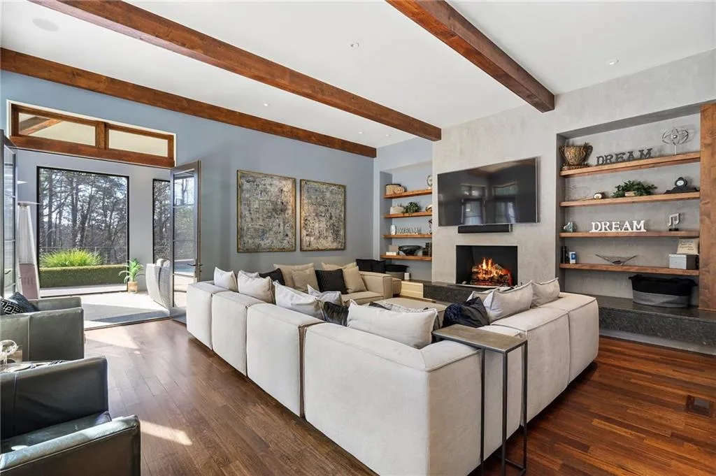 French doors open to screened patio with another fireplace overlooking the pool.