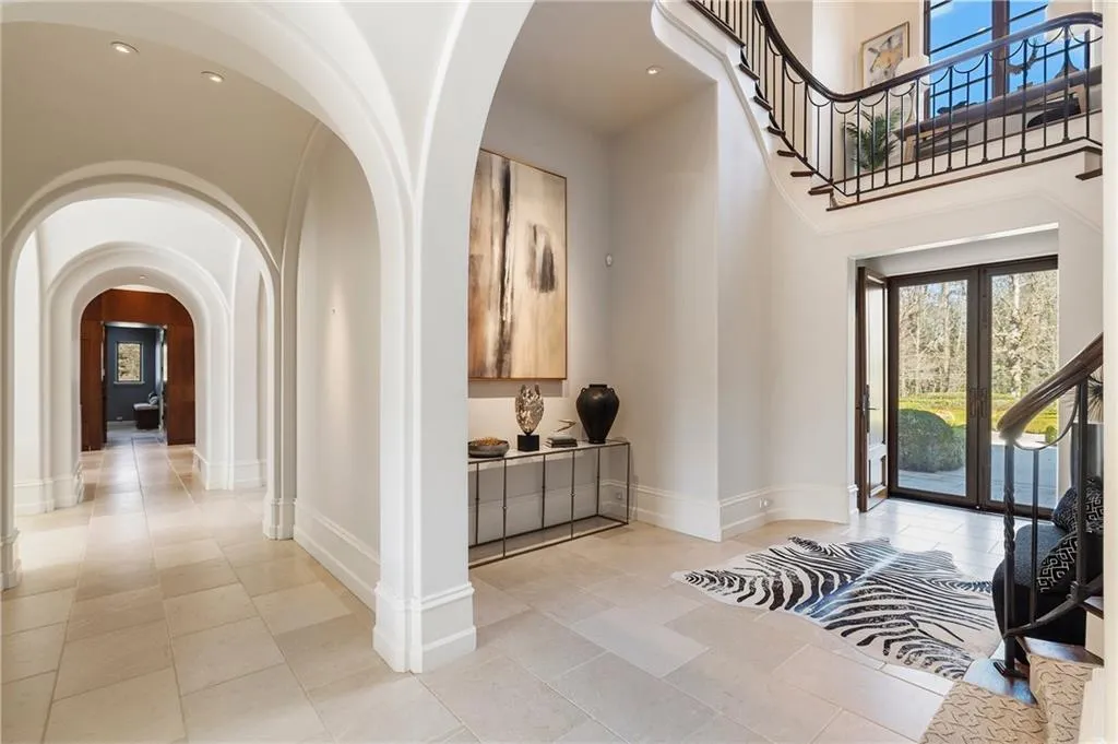 Two story open foyer with open stair and wrought iron railings.