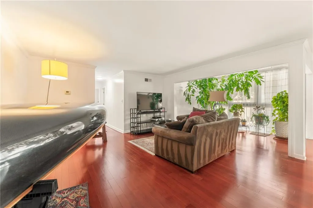 Campari colored wood flooring throughout the living, dining and sunroom areas.