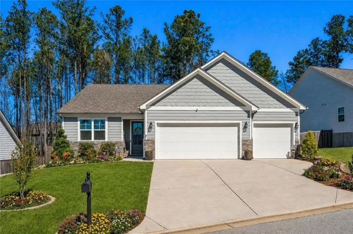 Contemporary residence featuring a two-car garage with individual doors, a concrete driveway, and a shingle roof