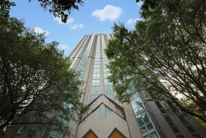 High-rise exterior with vertical window arrays, architectural concrete facade, and integrated glass elements