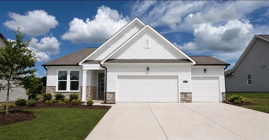 White siding exterior with a prominent gable, stone accents, and a two-car garage