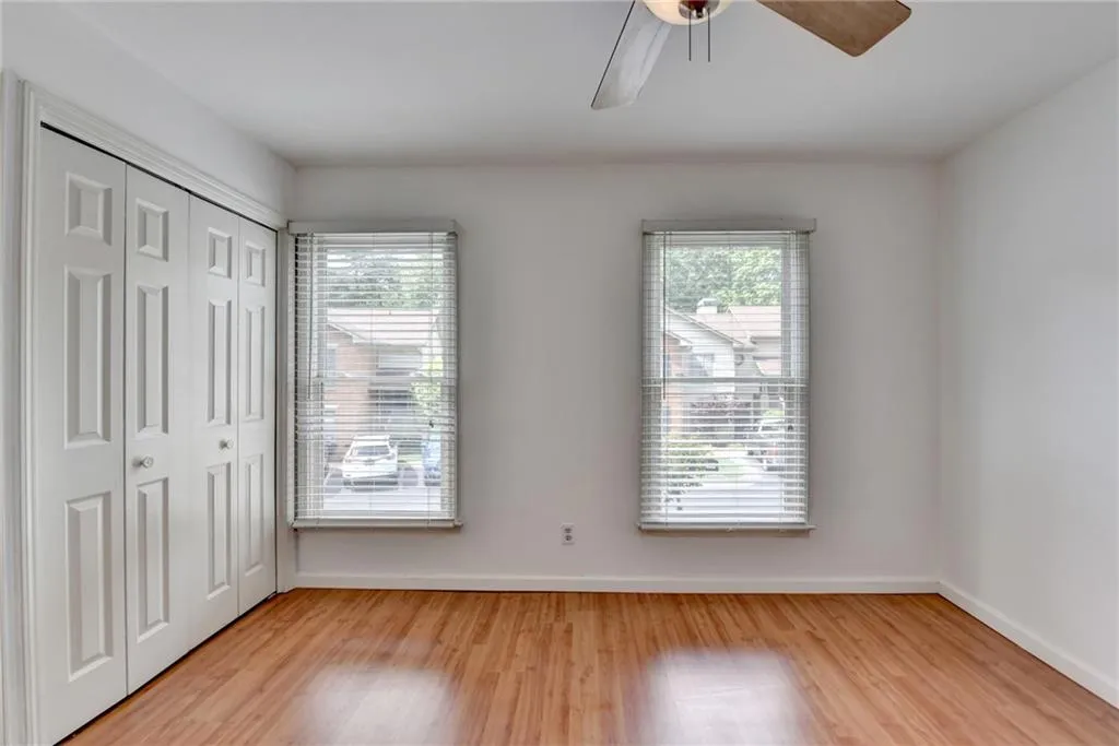Unfurnished bedroom featuring baseboards, multiple windows, and light wood-style flooring