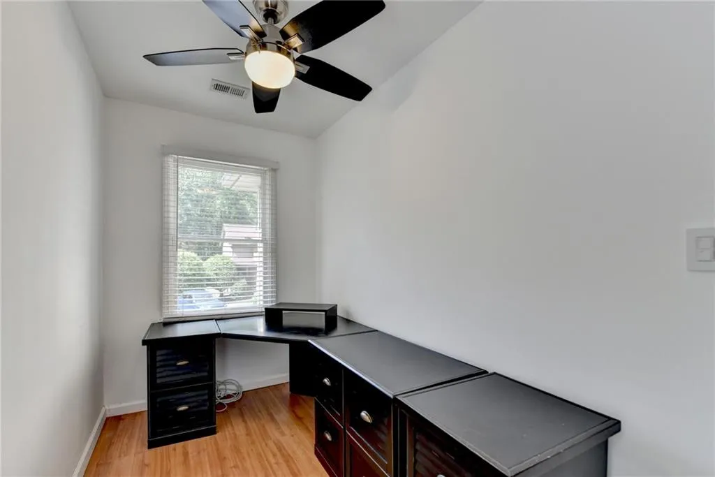 Home office featuring baseboards, visible vents, ceiling fan, and light wood-style floors