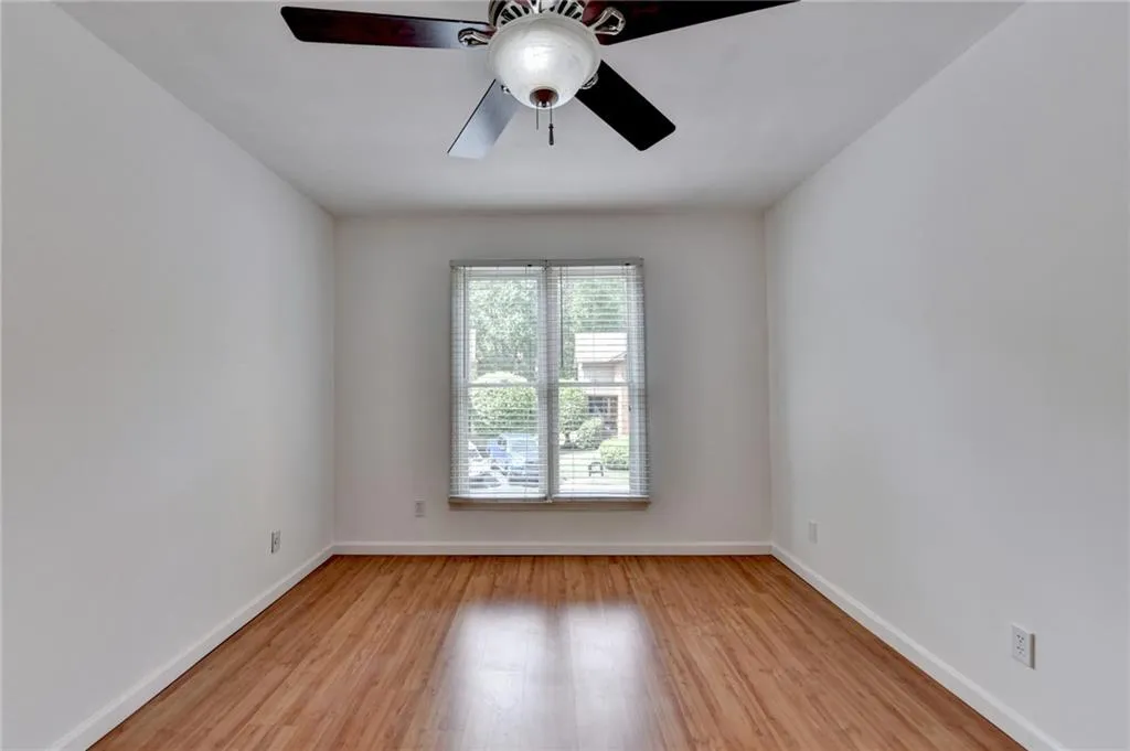 Spare room featuring baseboards, light wood-type flooring, and ceiling fan