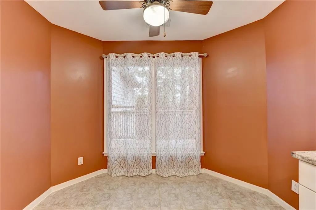 Spare room with a ceiling fan and baseboards