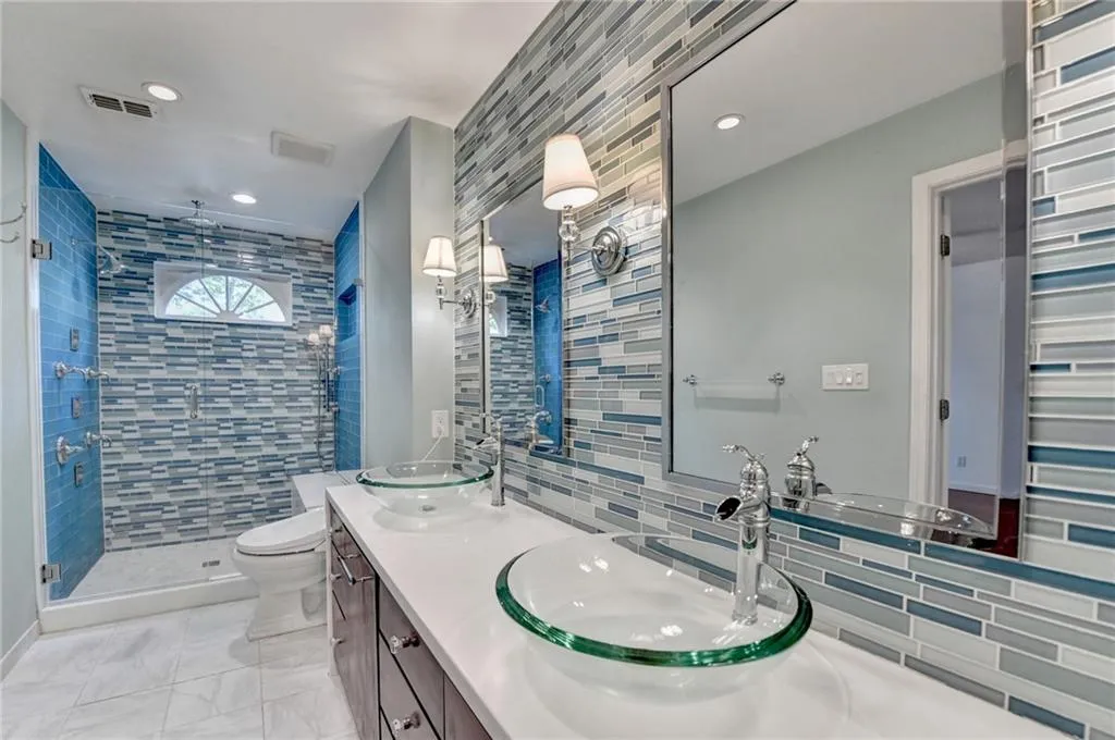 Full bathroom featuring tasteful backsplash, visible vents, a shower stall, and a sink