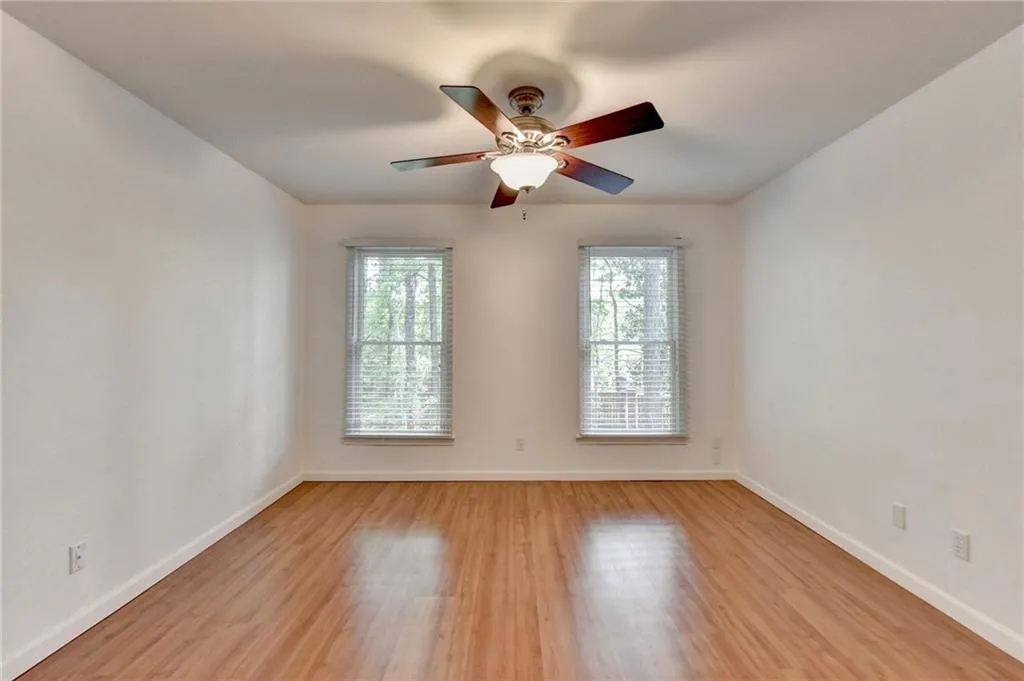 Empty room with baseboards, ceiling fan, and light wood-style flooring