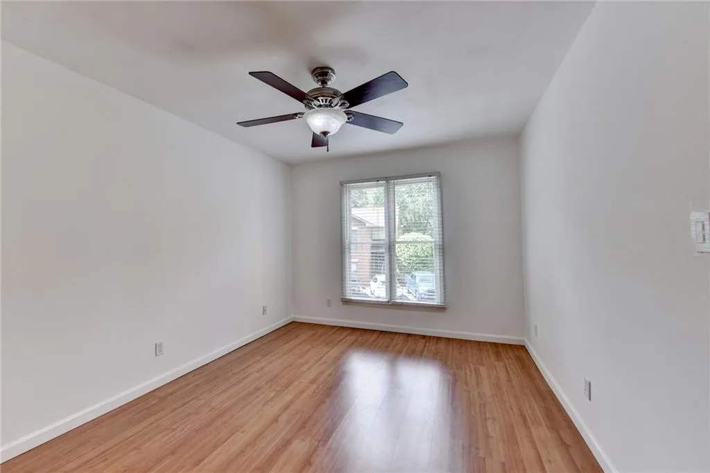 Unfurnished room featuring baseboards, light wood-type flooring, and ceiling fan
