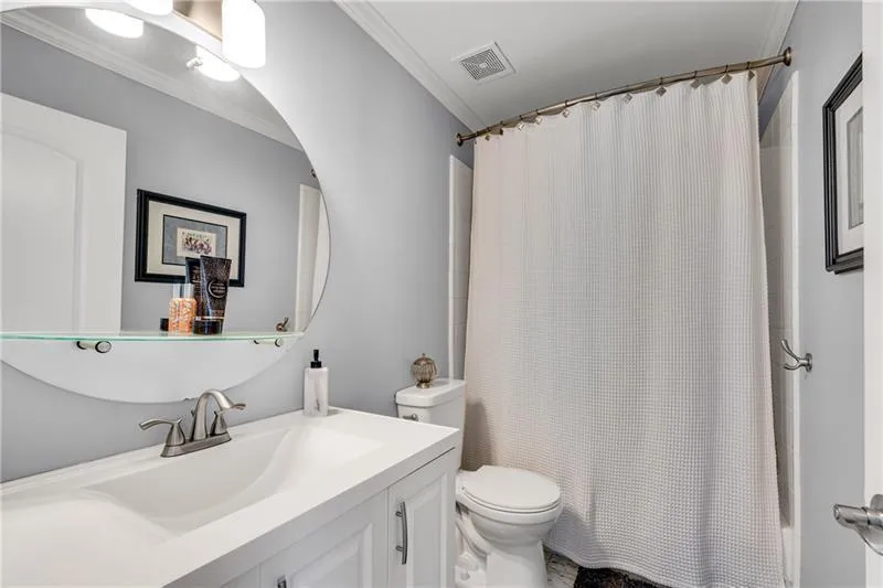 Renovated Upper Level Hall Bath with New Carrera Marble Vanity & Floor, Vanity Mirror with Cosmetic Shelf, & Tiled Tub/Shower.
