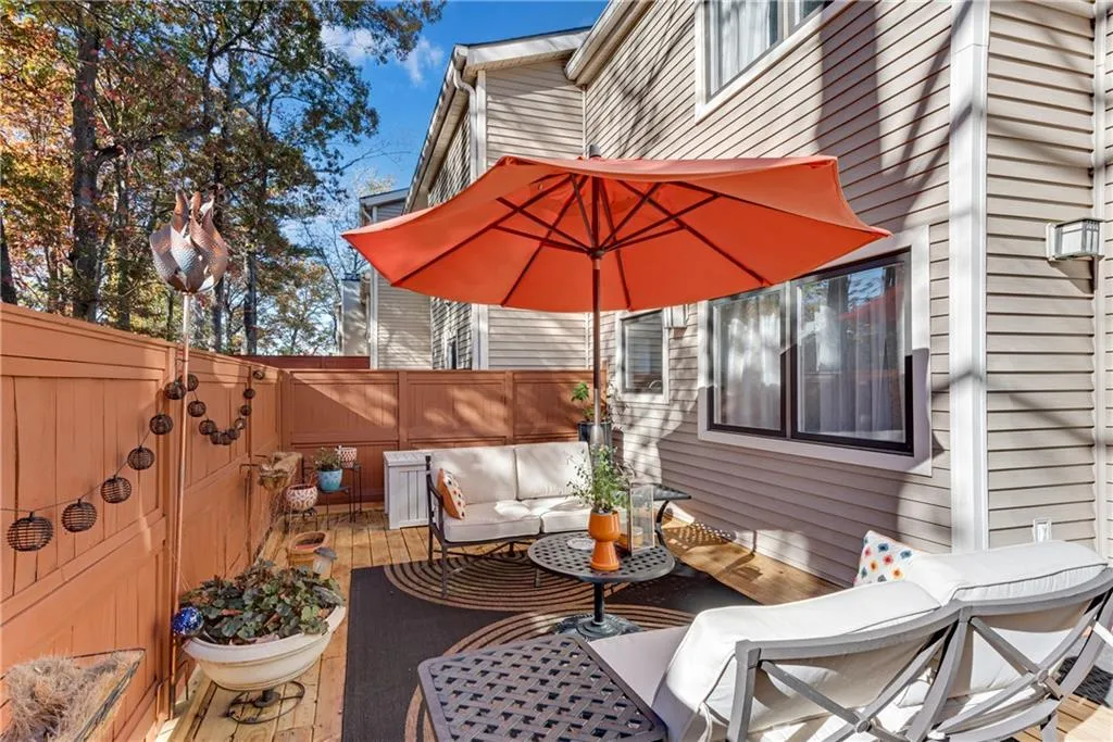 Fenced backyard with a wooden deck and an outdoor hangout area