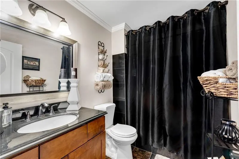 Main Level Bathroom features Granite Vanity Top, Tiled Tub/Shower Combo, Tile Floor and Crown Moulding.