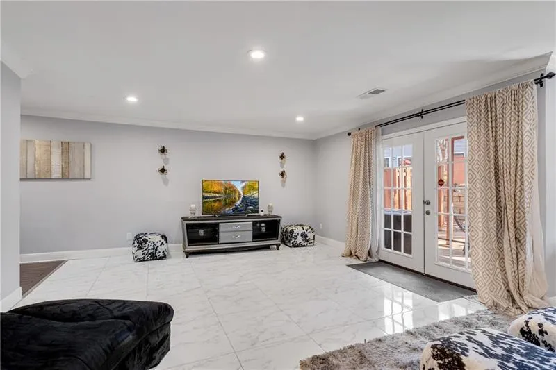 Opposite view of Main Floor Bonus/BR/Flex Rm with Recessed Lighting a Double French Doors leading to Private Patio.