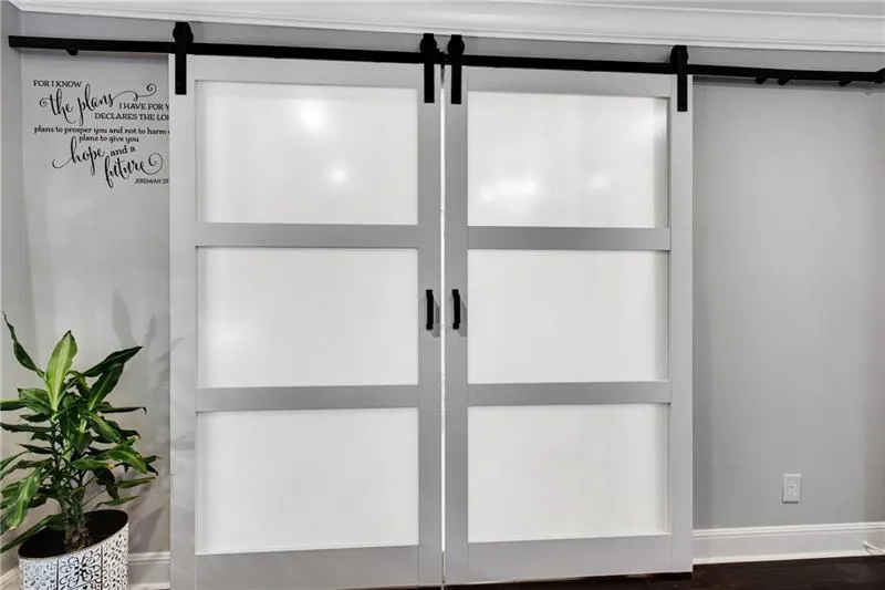 New Double Barn-Style sliding doors lead to Primary Bath with Carrera Marble Floors, Double Vessel Sink Vanity & Incredibly Oversized Bathtub/Shower featuring Split Stone Accent Wall.