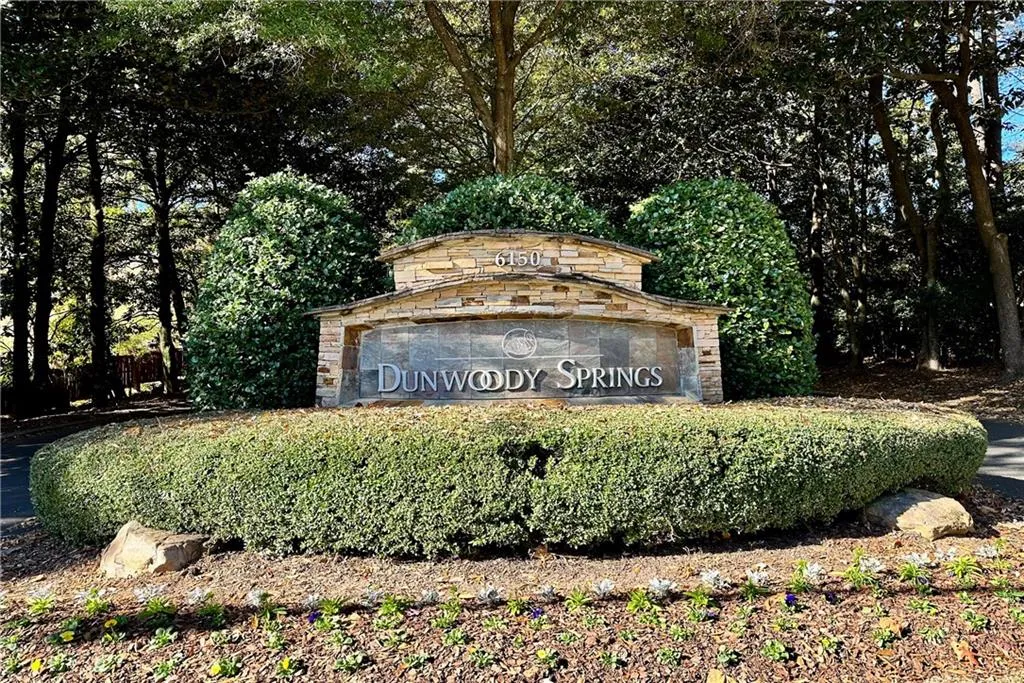 Community sign with view of wooded area