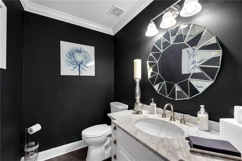 Strikingly Elegant Updated Powder Rm featuring Custom Painted walls, Crown Moulding & Carrera Marble-topped Vanity,