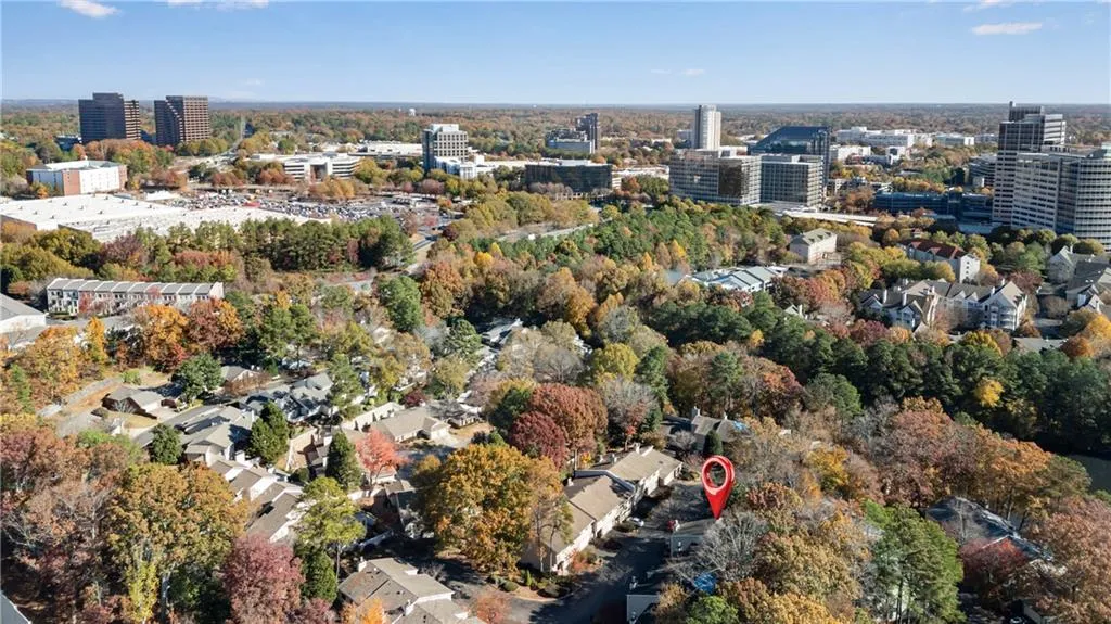 Aerial overview of property's location with nearby urban area and a tree filled landscape