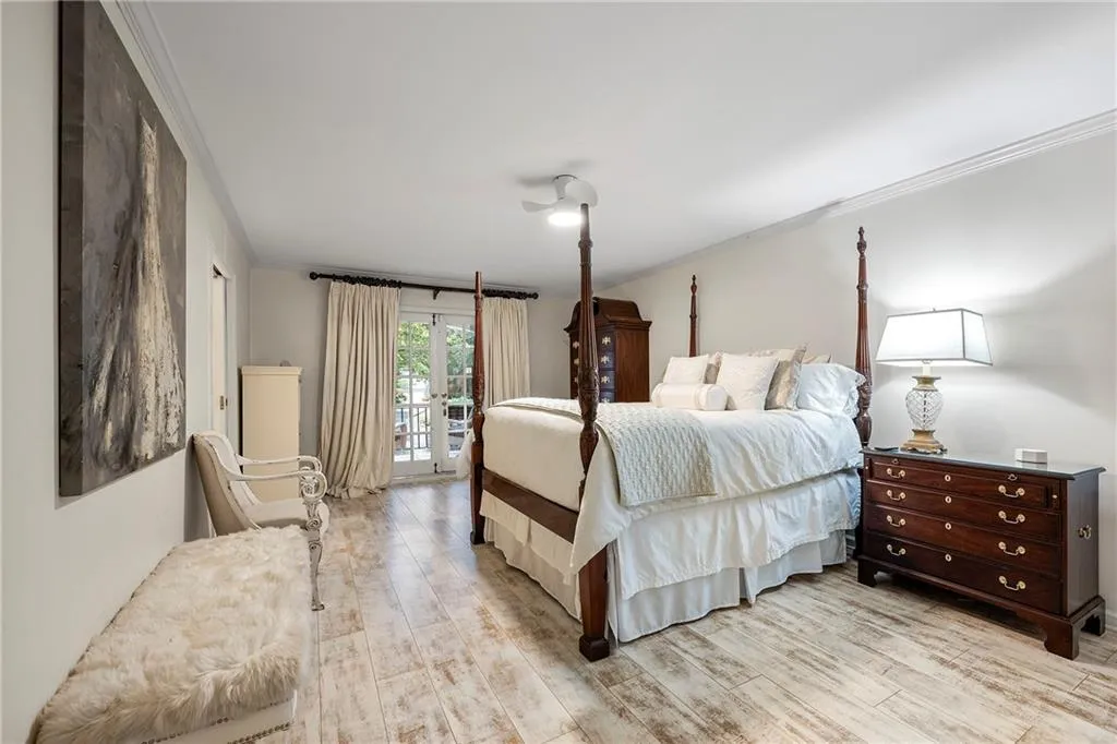 Oversized Master Bedroom with French Doors to a Private Deck  featuring light hardwood / wood-style flooring, access to exterior, and crown molding