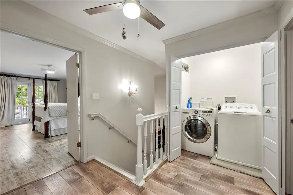Washroom with washing machine and dryer, light hardwood / wood-style floors, crown molding, and ceiling fan