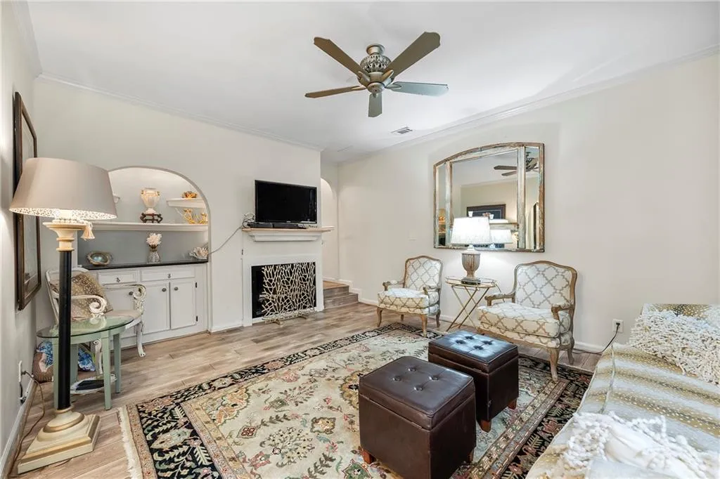 Living room featuring ornamental molding, light hardwood / wood-style floors, and ceiling fan