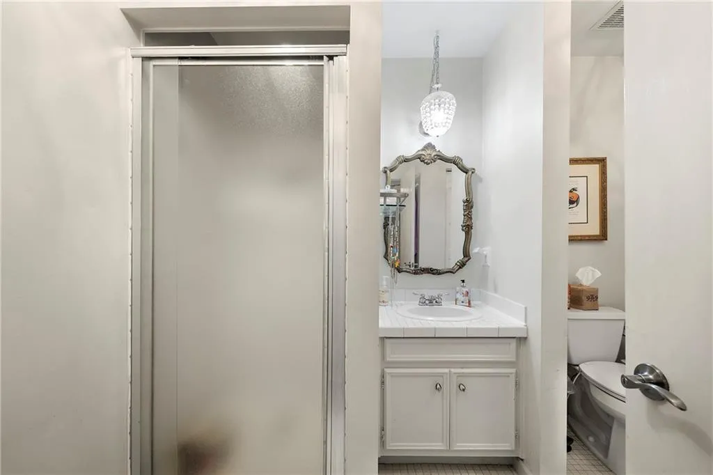 Bathroom 2 with tile flooring, an enclosed shower, vanity, and toilet