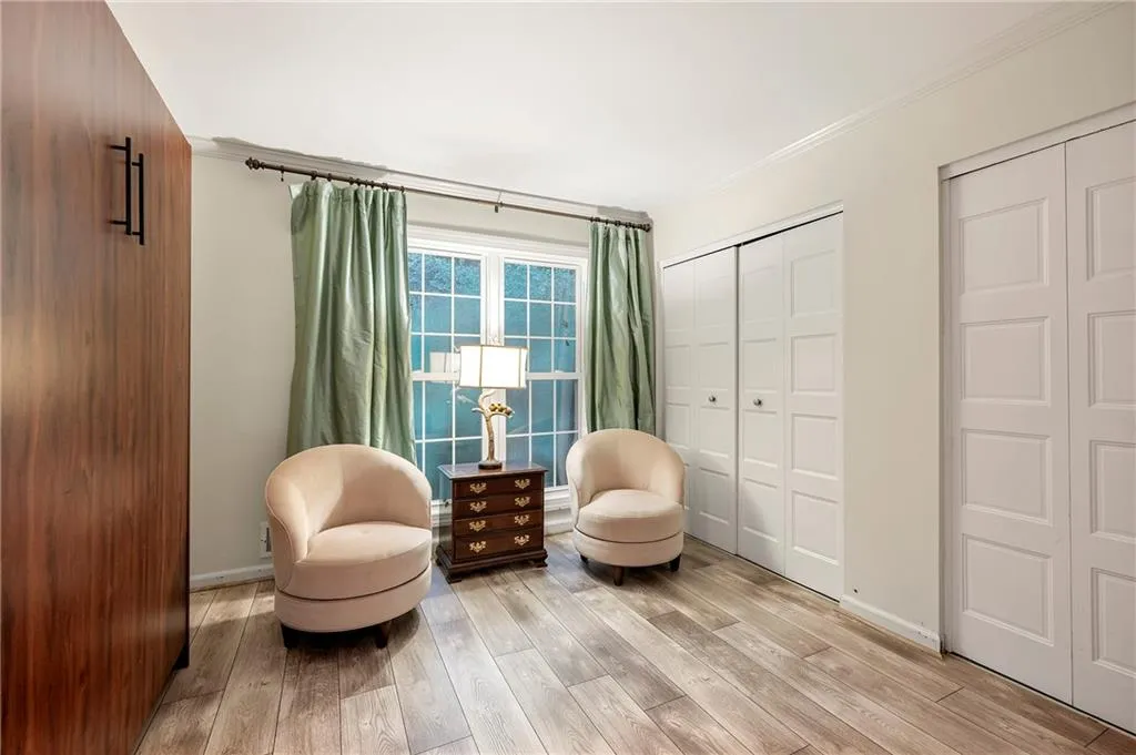 Bedroom 3 or office with a Murphy Bed with crown molding and light hardwood / wood-style floors