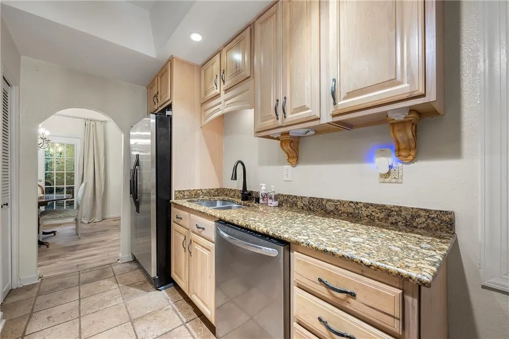Kitchen featuring light brown cabinetry, stainless steel appliances, sink, and stone countertops