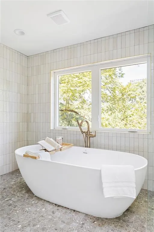 Bathroom with tile walls and a freestanding bath