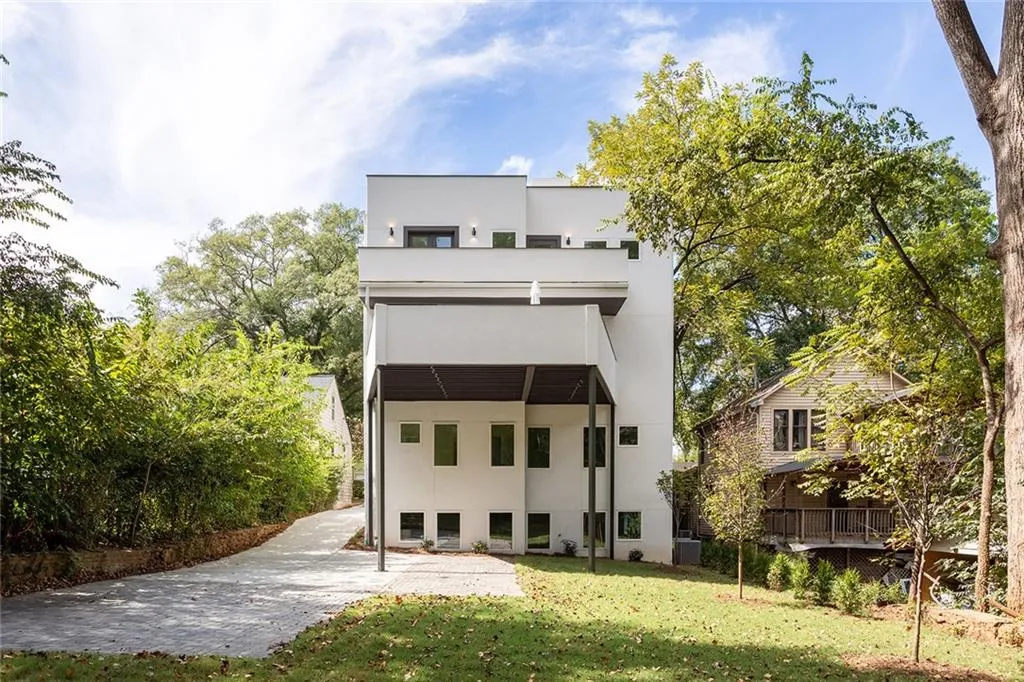 Rear view of house with a yard, stucco siding, and a patio