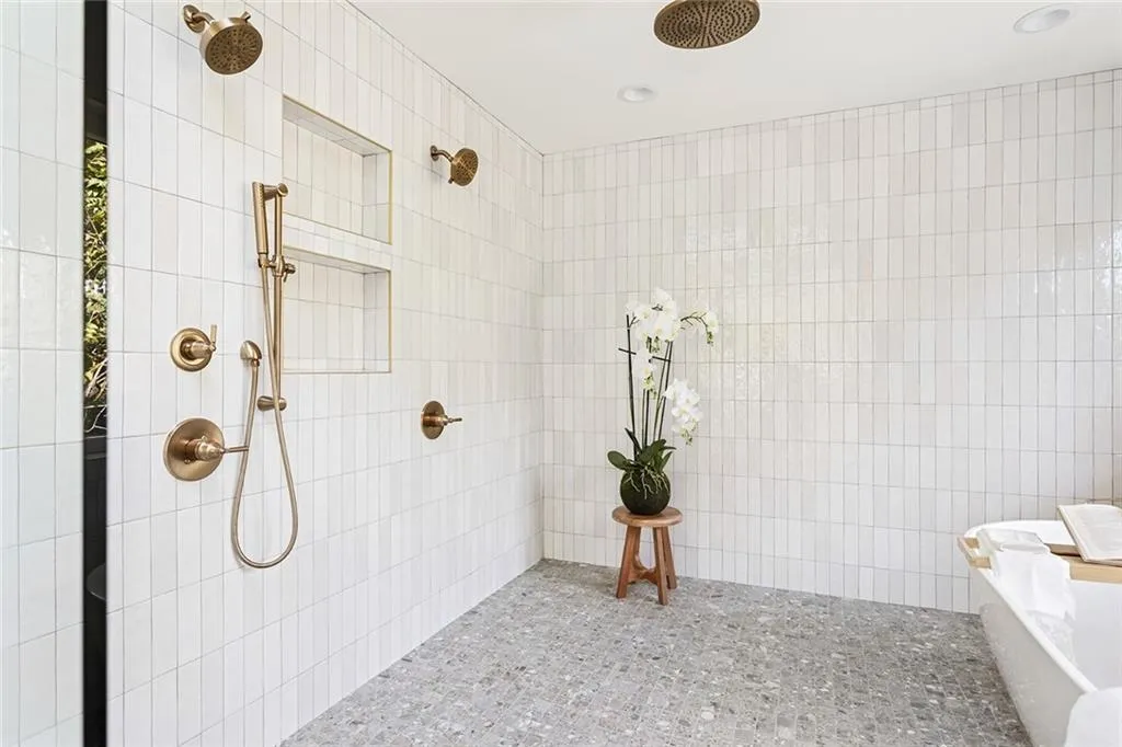 Bathroom with tiled shower and tile walls