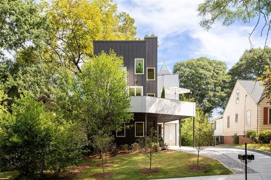 Contemporary home with board and batten siding, a front yard, driveway, and a carport