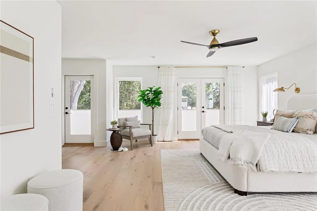 Bedroom with access to exterior, french doors, multiple windows, and light wood-type flooring