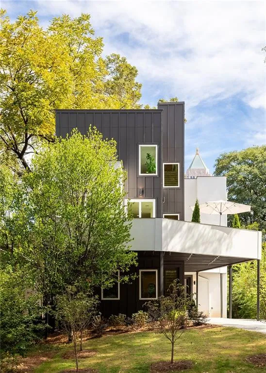 Modern home featuring board and batten siding, a patio, and a balcony