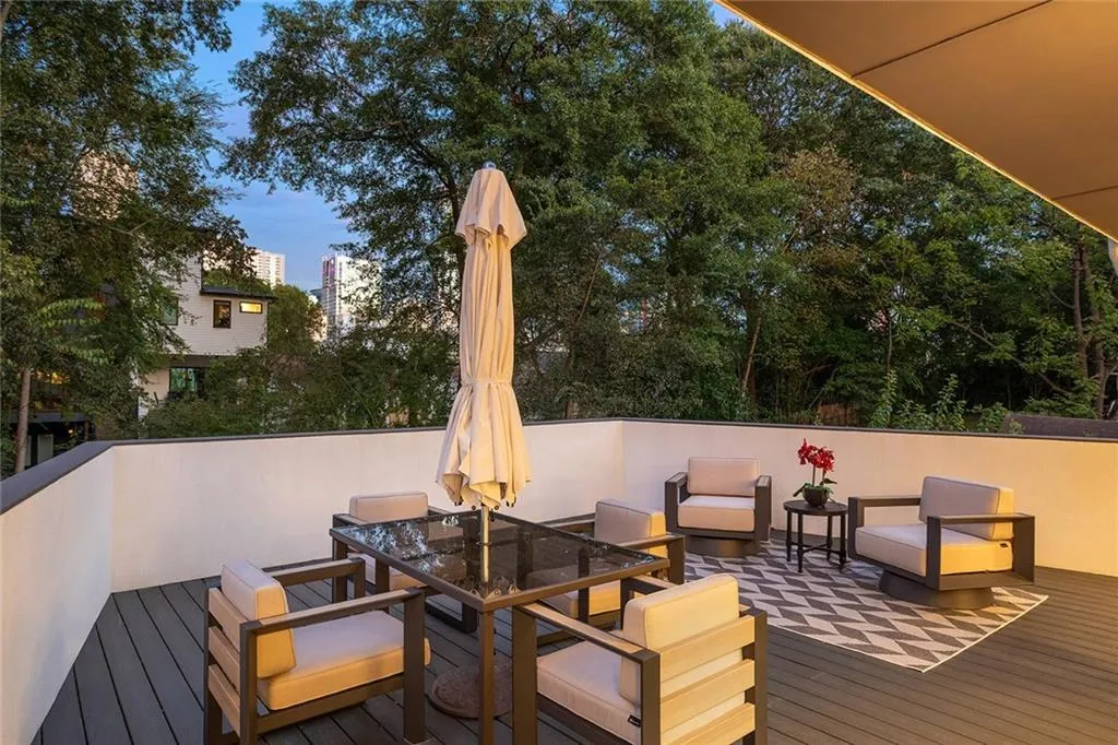 Deck at dusk with outdoor dining area and a view of city