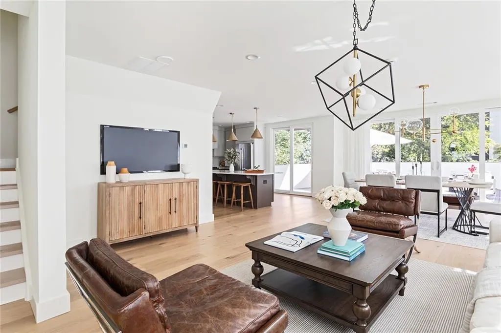 Living area with light wood-style flooring, a chandelier, recessed lighting, and stairway