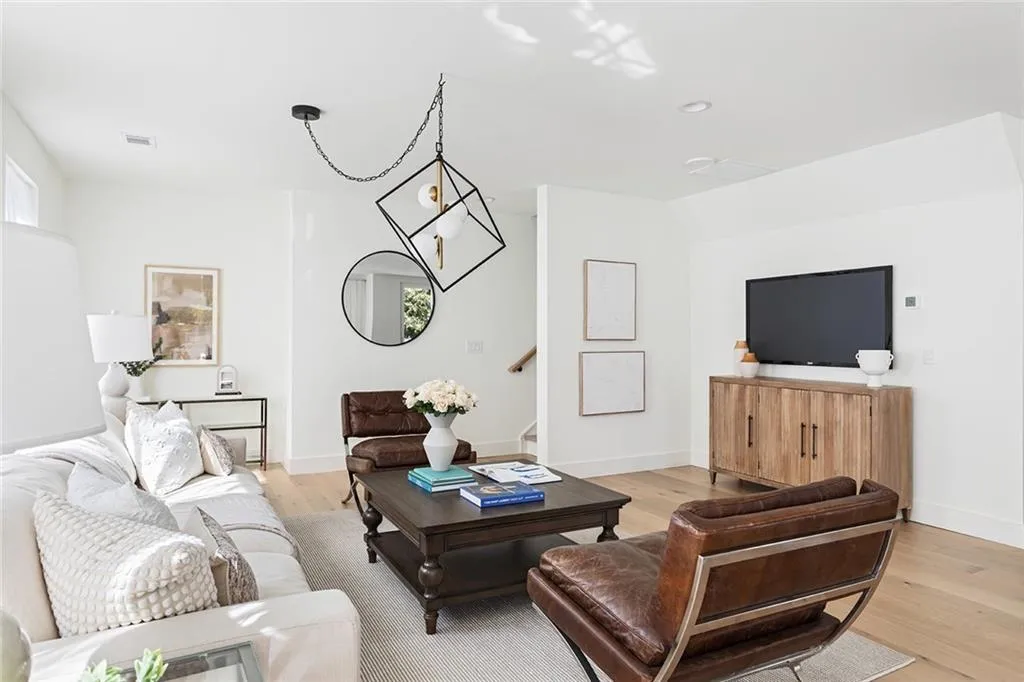 Living room with light wood-type flooring, stairway, and recessed lighting