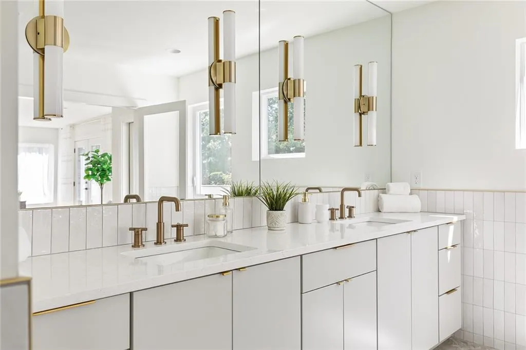Bathroom with plenty of natural light, double vanity, tile walls, and wainscoting