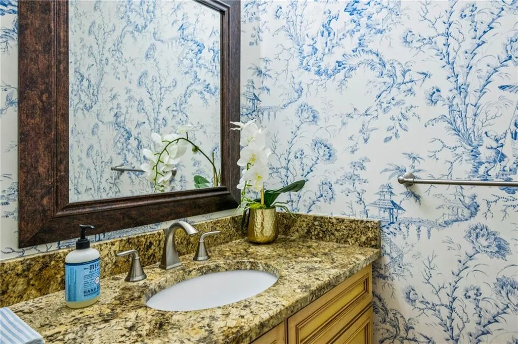 Bathroom with vanity and wallpapered walls